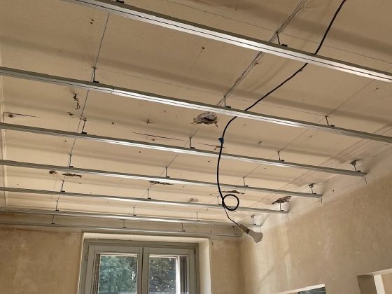 Structure de plafond installée sous des poutres apparentes